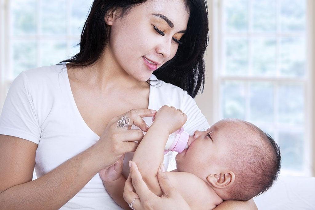 người chăm sóc cho chó con bú bình